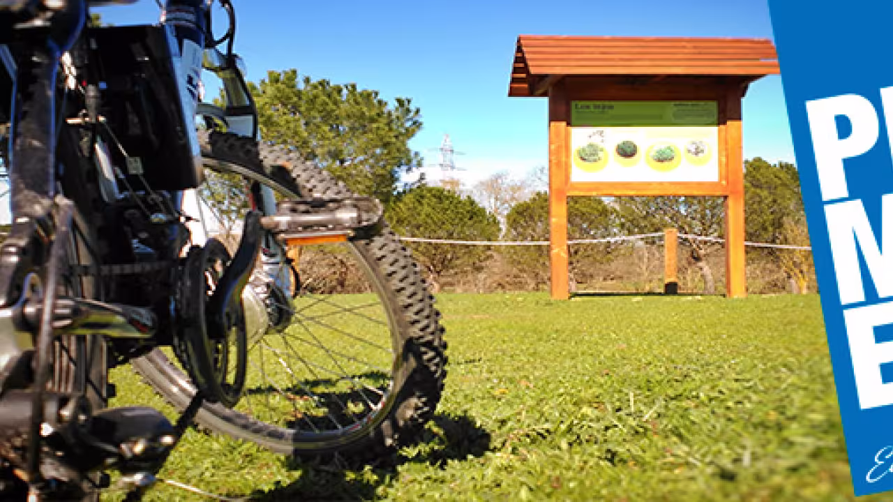 Bicicleta aparcada en un entorno natural junto a un panel informativo